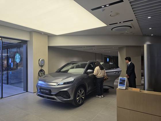 지난달 25일 서울 용산구 비야디(BYD) 용산 전시장에서 한 손님이 딜러의 안내를 받아 전기차 '아토3'를 살펴보고 있다. 오삼권 기자