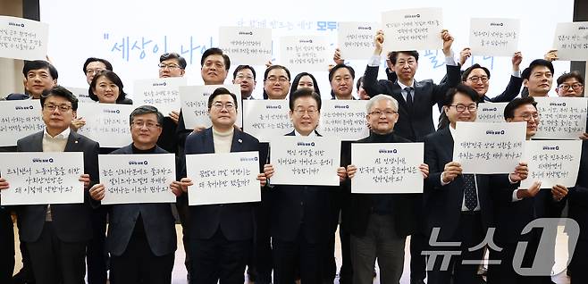 이재명 더불어민주당 대표가 7일 오전 서울 여의도 국회의원회관에서 열린 '다함께 만드는 세상, 모두의 질문Q 출범식'에서 참석자들과 손피켓을 들고 기념촬영을 하고 있다. 2025.2.7/뉴스1 ⓒ News1 김민지 기자