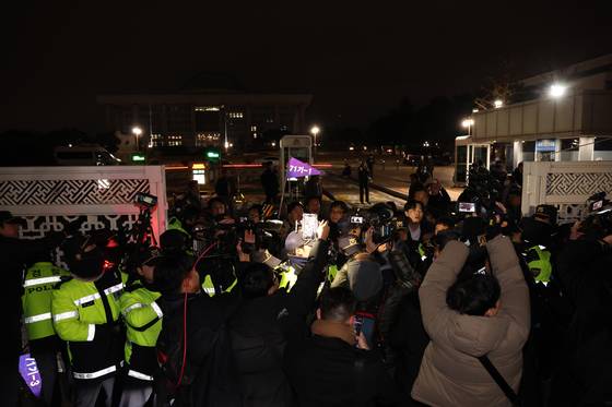 윤석열 대통령이 비상계엄을 선포한 지난해 12월 3일 밤 경찰 병력이 통제중인 국회 정문에서 국회 관계자들이 진입을 시도하고 있다. 김경록 기자