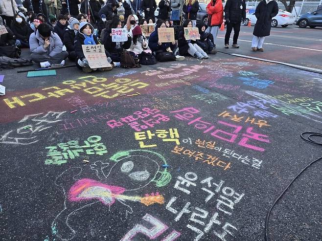 8일 ‘윤석열퇴진 10차 대학생 시국대회’에 참여한 학생들이 현 시국에 대한 의견과 자신들이 바라는 세상에 대한 바람을 바닥에 분필로 적은 모습. 김가윤 기자