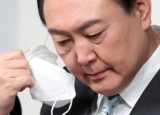 윤석열 당시 국민의힘 대선 후보가 2022년 1월 서울 영등포구 여의도 당사에서 생활밀착형 공약 행보의 일환으로 '4월 전기요금 인상 백지화' 공약을 발표하기 위해 마스크를 벗고 있다. 오대근 기자