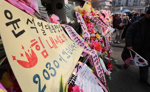 공수처와 경찰의 윤석열 대통령 2차 체포영장 집행 시도가 임박한 가운데 14일 서울 용산구 한남동 대통령 관저 인근에 윤석열 대통령을 응원하는 지지자들의 화환이 세워져 있다. 뉴스1