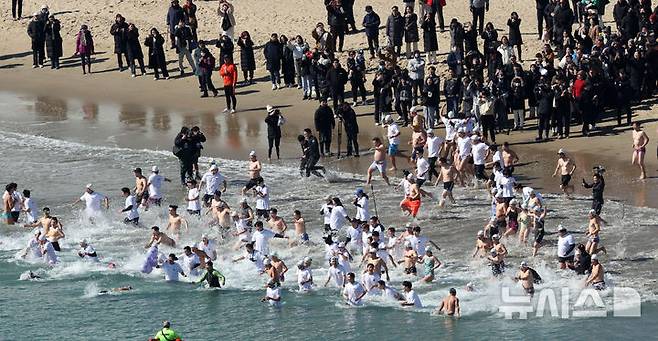 [부산=뉴시스] 하경민 기자 = '제38회 부산 북극곰 축제'가 열린 9일 부산 수영구 광안리해수욕장에서 시민과 관광객 등 인간 북극곰들이 차가운 겨울바다에 뛰어들고 있다. 2025.02.09. yulnetphoto@newsis.com