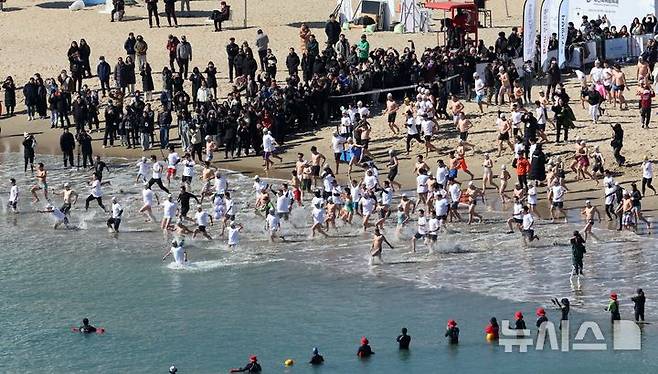 [부산=뉴시스] 하경민 기자 = '제38회 부산 북극곰 축제'가 열린 9일 부산 수영구 광안리해수욕장에서 시민과 관광객 등 인간 북극곰들이 차가운 겨울바다에 뛰어들고 있다. 2025.02.09. yulnetphoto@newsis.com