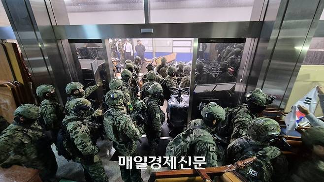지난해 12월 4일 오전 1시 9분께 국회의사당 본관 2층에서 경계 중이던 특전사 병력이 국회의 계엄 해제 의결 소식이 전해진 뒤 철수 중이다. [이상현 기자]