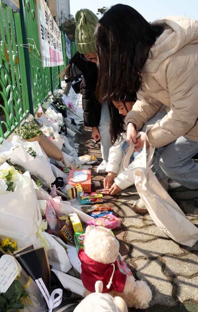 11일 오후 초등학생 피살사건이 발생한 대전 서구의 한 초등학교 정문 옆 담장에서 초등학생들이 국화꽃과 과자·음료 등을 놓으며 고 김하늘(8)양을 추모하고 있다. 뉴시스