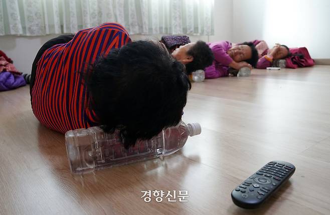 두지마을 아짐들이 지난달 10일 오후 경로당에서 물통 베개를 베고 잠을 자고 있다. | 박채연 기자