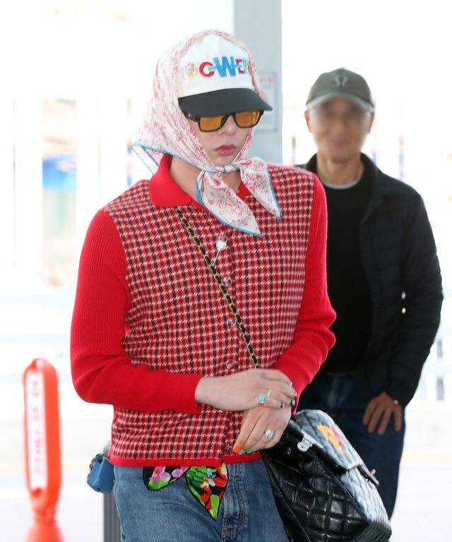 그룹 빅뱅 지드래곤이 머리에 스카프를 두르고 붉은색 가디건을 걸친 채 지난해 11월 4일 오후 인천국제공항을 통해 홍콩으로 출국하고 있다. 뉴시스
