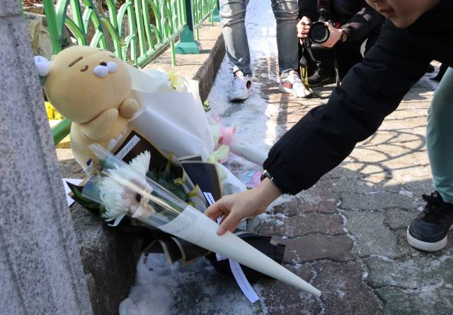 ▲11일 오전, 초등생 1학년 여아가 살해당한 대전 서구 한 초등학교 앞에서 한 아동이 국화꽃을 두고 추모하고 있다. 지난 10일 오후 5시 50분께 이 학교에서 초등학교 1학년생인 A(8)양이 흉기에 찔려 심정지 상태로 발견됐으나 숨졌다. 경찰은 현장에서는 다친 채 발견된 교사 B(40대)씨가 A양을 찌른 뒤 자해한 것으로 보고 자세한 사건 경위를 조사하고 있다. ⓒ연합뉴스