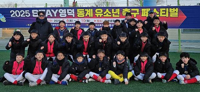  ‘2025 STAY 영덕 동계유소년 축구 페스티벌’에서 무패 우승을 거머쥔 안양AFA U-12, U-11 선수단과 코치진이 주먹을 쥐고 기념촬영을 하고 있다. 사진제공｜안양AFA