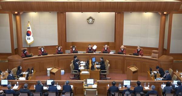 ▲13일 헌법재판소 윤석열 대통령 탄핵심판 8차 변론기일을 마무리하며 문형배 헌법재판소장 권한대행이 재판진행 대본을 들어보이고 있다. 사진=헌재영상 캡쳐