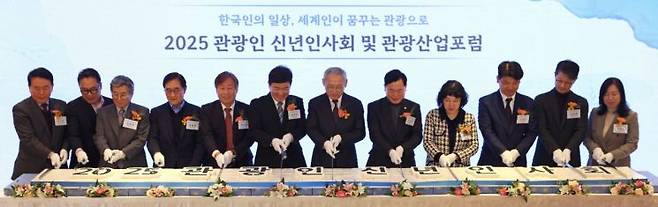 유인촌 문화체육관광부 장관(오른쪽 여섯 번째)과 관광업계 관계자들이 14일 서울 중구 롯데호텔에서 열린 2025 관광인 신년인사회에서 기념 떡 케이크를 자르고 있다.   [사진 제공= 문화체육관광부]
