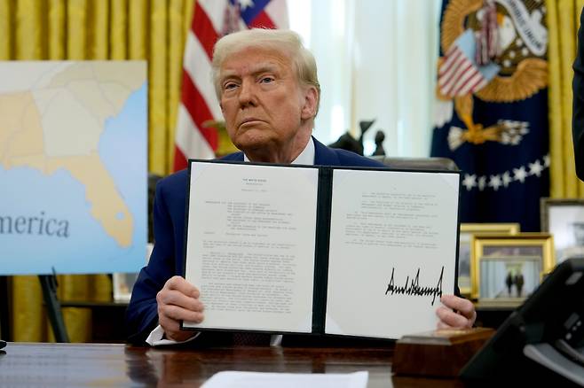 현지 시각 13일 도널드 트럼프 대통령이 워싱턴 백악관 집무실에서 상호관세 조치 행정명령에 서명한 뒤 들어보이고 있다./AP 연합뉴스