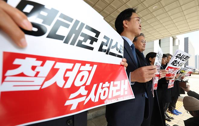 더불어민주당 명태균게이트 진상조사단이 14일 서울 서초구 대검찰청을 항의 방문하기 전 취재진 앞에서 손팻말을 들고 있다. <연합뉴스>