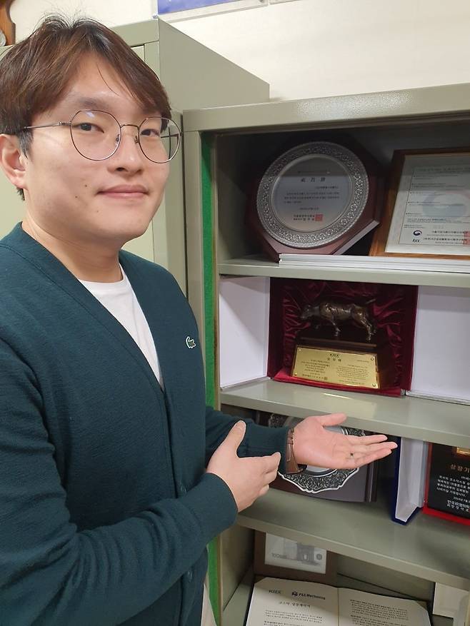 이준철 매니저가 코스닥 상장패를 보여주고 있다. 윤현주 기자