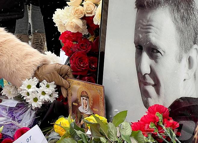 16일(현지시간) 러시아 모스크바 보리솝스코예 묘지에 있는 알렉세이 나발니의 묘지에서 시민들이 나발니 사망1주기를 추모하고 있다. ⓒ 로이터=뉴스1