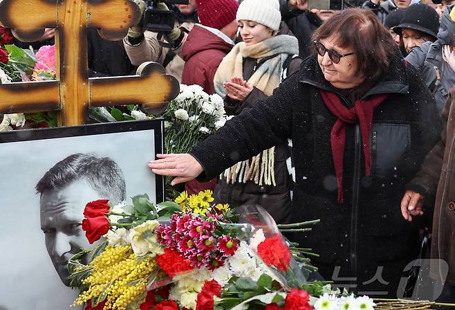 16일(현지시간) 러시아 모스크바 보리솝스코예 묘지에 있는 알렉세이 나발니의 묘지에서 시민들이 나발니 사망1주기를 추모하고 있다. ⓒ 로이터=뉴스1