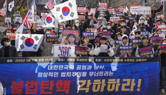 지난 17일 서울 관악구 서울대 학생회관 앞에서 자유민주주의를 수호하는 서울대인이 주최한 탄핵 반대 시국선언에서 소속 학생들과 보수단체 회원들이 탄핵 기각을 촉구하고 있다. 연합뉴스