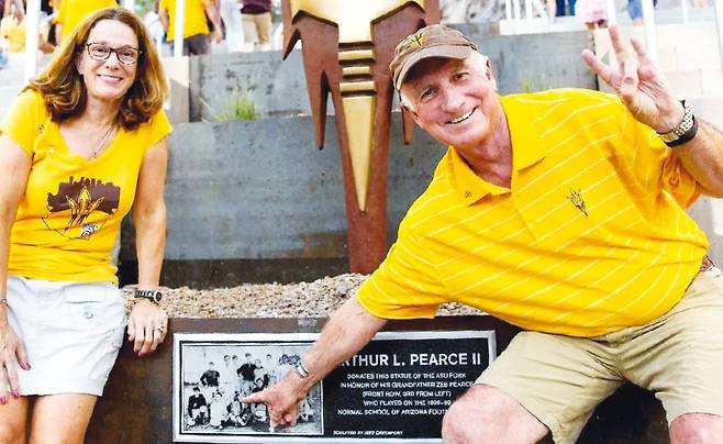 미국 템피 애리조나주립대(ASU)에 있는 대학기반은퇴자공동체(UBRC) '미라벨라 앳 ASU' 입주민이 ASU 스포츠팀 '선 데블스'의 삼지창을 형상화한 조형물 앞에서 손가락으로 삼지창 모양을 만들어 보이고 있다.  미라벨라 앳 ASU 제공