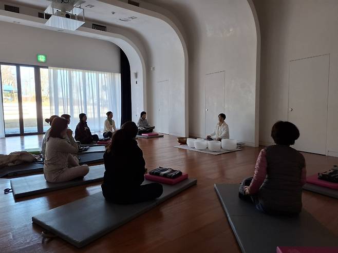 Participants listen to the instructor during a singing bowl class at the Gangnam Healing Center in Gaepo-dong, Seoul. (Shin Ji-hye/The Korea Herald)