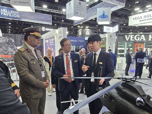 강구영 KAI 사장(가운데)가 17~ 21일(현지시간) 아랍에미리트(UAE) 수도 아부다비에서 개최되는 국제방산전시회(IDEX) 2025에서 UAE 군 관계자와 KAI 부스를 둘러보고 있다. [사진=KAI]