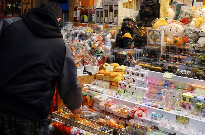 기념품 구경하는 관광객 (제주=연합뉴스) 백나용 기자 = 제주시 동문재래시장 내 관광기념품점에서 관광객이 기념품을 고르고 있다. 2025.2.13 dragon.me@yna.co.kr