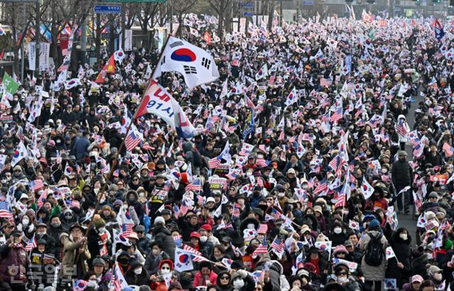 윤석열 대통령 탄핵반대 국민대회가 15일 서울 광화문 사거리 일대에서 열린 가운데 참석자들이 태극기와 성조기를 흔들고 있다. 홍인기 기자