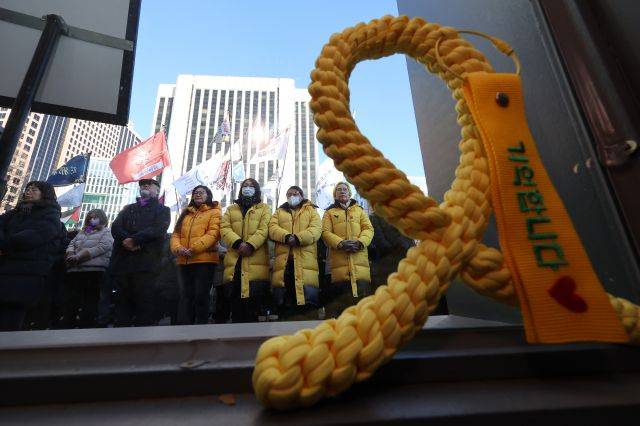 지난달 29일 오후 서울 중구 서울시의회 앞 세월호 기억 공간에서 열린 '세월호 참사 가족·시민 설 명절 상차림과 음식 나눔 행사'에서 유족 및 시민들이 김종기 4.16세월호 참사 가족협의회 운영위원장의 발언을 듣고 있다. 연합뉴스