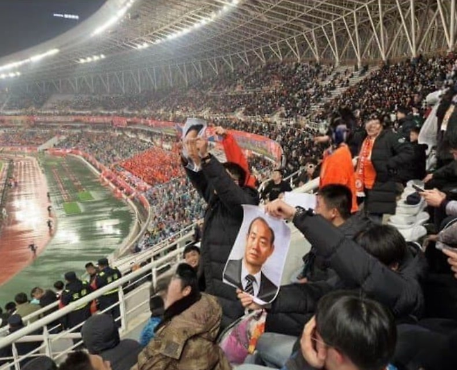 전두환과 북한 김정은 사진을 들고 광주를 도발하며 응원하고 있는 산둥 관중들. 온라인 커뮤니티