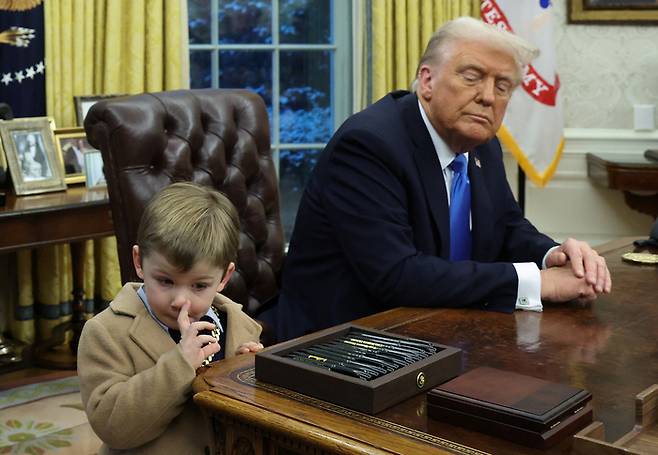 지난 11일(현지 시각) 일론 머스크 테슬라 최고경영자(CEO) 아들 엑스가 백악관 오벌오피스에 방문해 도널드 트럼프 미국 대통령 옆에서 코를 파고 있다. 사진=로이터 연합뉴스