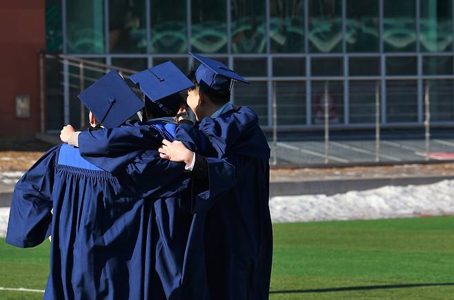 19일 서울 성북구 국민대학교에서 열린 전기 학위수여식에서 졸업생들이 기념촬영을 하고 있다. [연합]