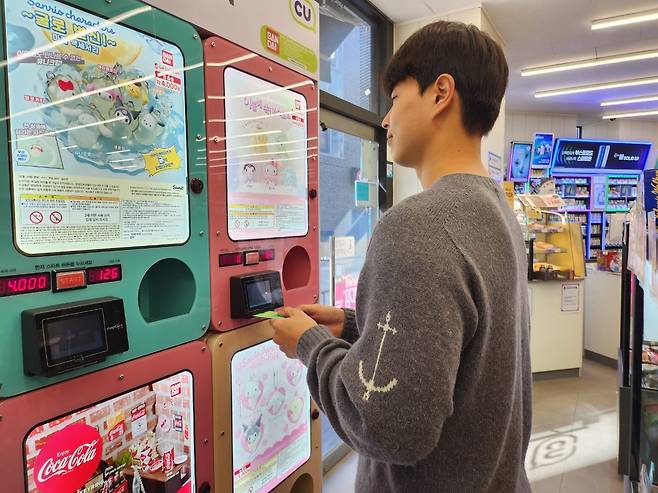 CU 혜화마로니에공원점에서 고객이 ‘피규어 캡슐 뽑기 기계’를 이용하고 있다.  [BGF리테일 제공]
