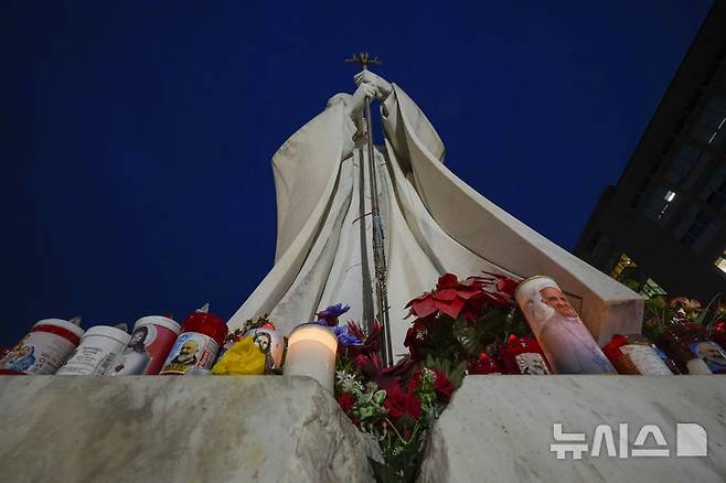 [로마=AP/뉴시스] 19일(현지 시간) 이탈리아 로마의 제멜리 병원 앞에 있는 요한 바오로 2세 교황 동상 밑에 프란치스코 교황의 건강을 기원하는 촛불이 놓여 있다. 2025.02.24.