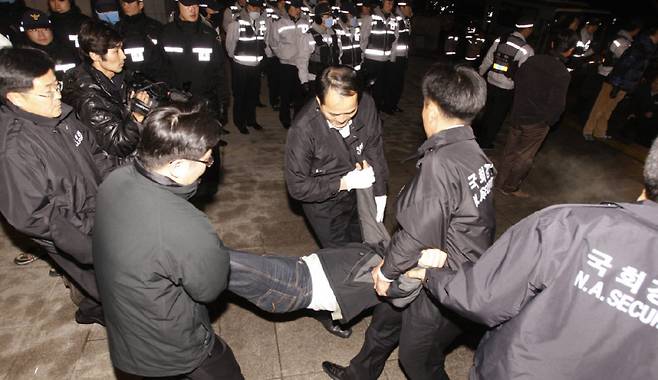 2009년 1월 5일 국회 경위들이 서울 여의도 국회 본회의장 앞에서 농성 중인 30여 명의 민노당 의원들과 당직자·보좌진에 대해 강제 해산에 나서고 았다. [동아DB]