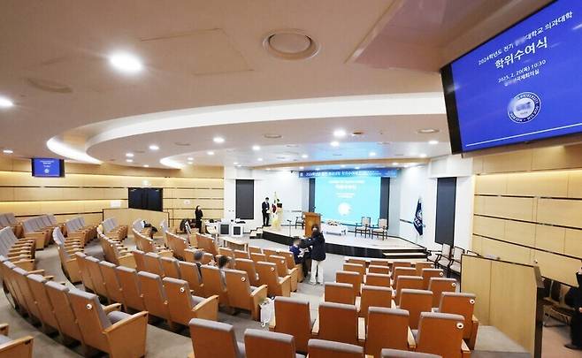 지난 20일 서울 한 의과대학 졸업식에서 참석자들이 대기하고 있다. 이날 졸업식에는 극소수의 졸업생만 참석했다. 한편 의대생 집단 휴학으로 졸업생을 배출하지 못한 의대에서는 전기 학위수여식을 취소하고 있다. 연합뉴스