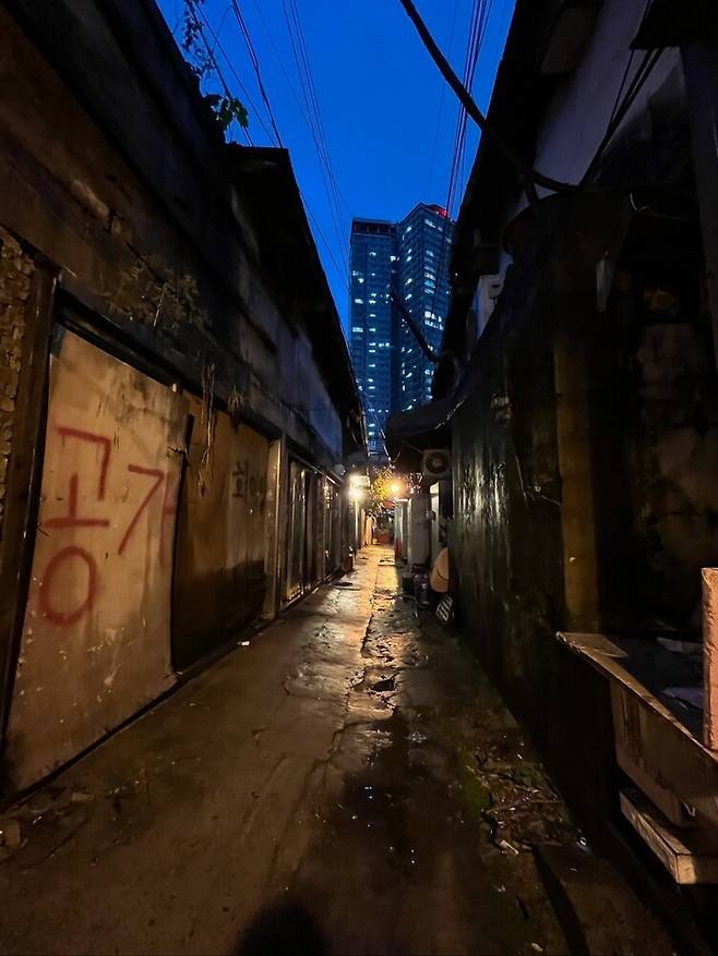 서울 성북구 신월곡1구역 재개발 이주가 본격화하면서 미아리 성매매 집결지엔 공가가 늘었다. 생계를 위해 미아리로 온 업계 노동자들은 최근 급격한 수입 감소로 생활고를 겪고 있다. 공가 사이로 고층 건물이 보인다. 장윤미 다큐멘터리 감독 제공