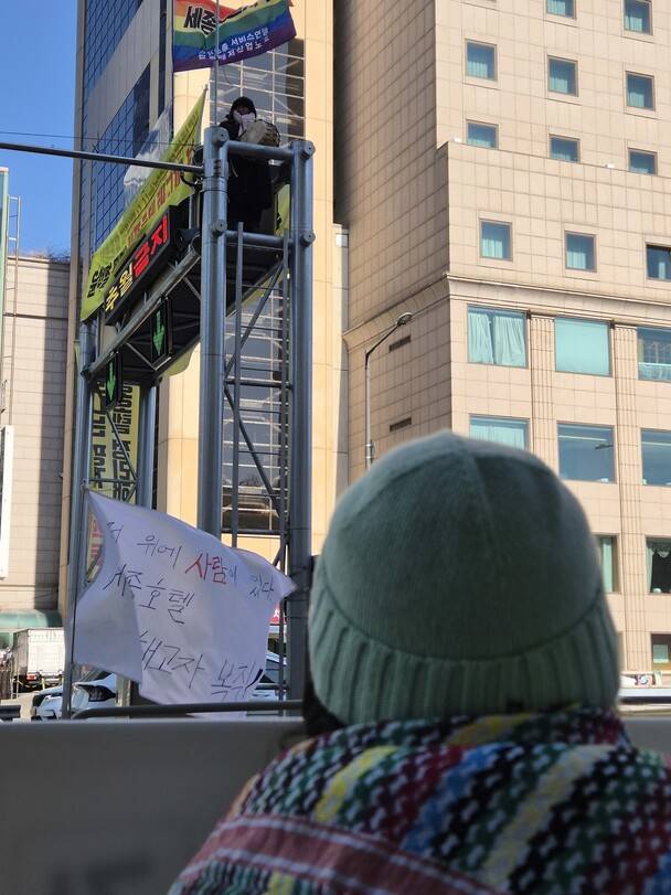 2025년 2월19일 시민 온화(활동명)가 고진수 세종호텔지부장을 바라보며 손피켓을 들고 있다. 신다은 기자