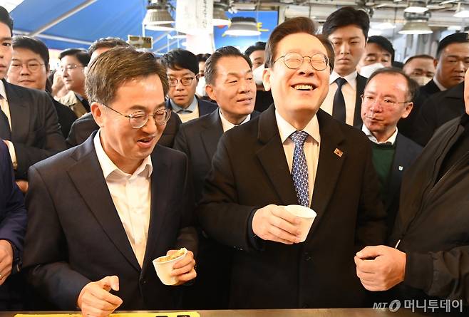 [수원=뉴시스] 김종택기자 = 이재명 더불어민주당 대표와 김동연 경기도지사가 21일 경기도 수원시 못골시장을 방문해 호떡을 시식하며 대화하고 있다. 2024.11.21. jtk@newsis.com /사진=김종택