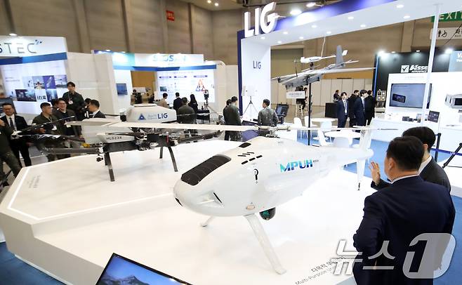 26일 부산 해운대구 벡스코 제1전시장에서 열린 'DSK 2025(드론쇼코리아)'에서 관람객들이 LIG넥스원부스에 전시된 하이브리드 수송드론 다목적 무인헬기 등 다양한 드론을 살펴보고 있다.  2025.2.26/뉴스1 ⓒ News1 윤일지 기자