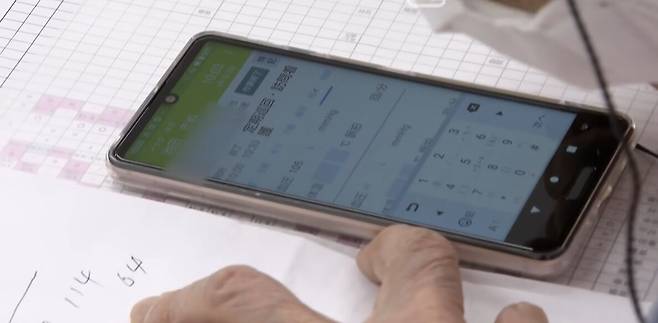 97세 간호사 이케다씨가 환자들의 혈압과 체온 등을 스마트폰에 입력하고 있다. 같이 일하는 젊은 간호사들은 그의 이런 모습에 '존경스럽다'며 감탄한다.