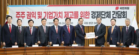 26일 서울 여의도 국회에서 열린 '주주 권익 및 기업가치 제고를 위한 경제단체 간담회'에서 권영세 국민의힘 비상대책위원장이 김창범 한국경제인협회 부회장으로부터 상법 개정에 대한 경제8단체 건의문을 전달받고 있다. 김 부회장은 ″(개정안 통과 시) 정상적인 경영 판단을 할 수가 없다″고 호소했다. 사진 연합뉴스