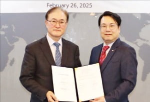 유문기 한화엔진 대표(오른쪽)와 안중호 팬오션 대표가 지난 26일 선박엔진 장기유지보수계약(LTSA)을 맺은 뒤 계약서를 들어 보이고 있다.
  /한화엔진 제공