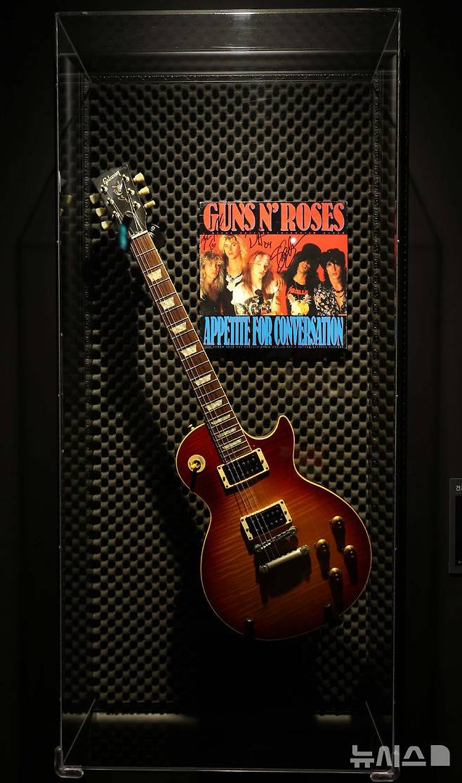 [서울=뉴시스] 고범준 기자 = 28일 서울 강남구 현대백화점 무역센터점 문화홀에서 열린 '위대한 뮤지션 100인전 vol.1'에서 건즈 앤 로지스 투어에서 슬래시가 연주한 기타가 전시되어 있다. 전시관은 아메리칸 퀸, 디바, 위대한 밴드, 위대한 기타리스트 컬렉션, 팝의 황제, 힙합, 그래미 & BTS 등 7개 공간으로 구성됐다. 2025.02.28. bjko@newsis.com