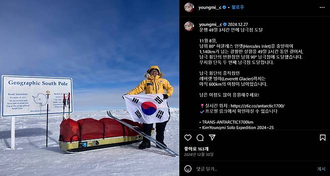 이번 남극대륙 횡단 중 남극점에 도착한 김영미 대장. 2008년 에베레스트 등정 때 함께한 태극기를 펼쳐 보이고 있다. 썰매 안에는 텐트, 식량, 연료, 탈출 장비 등이 들어 있다. /노스페이스