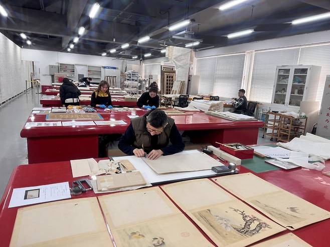 지난 21일 자금성 서화복원실에서 고서화 전문가들이 훼손된 옛 작품을 되살리는 작업을 하고 있다. 신경진 기자