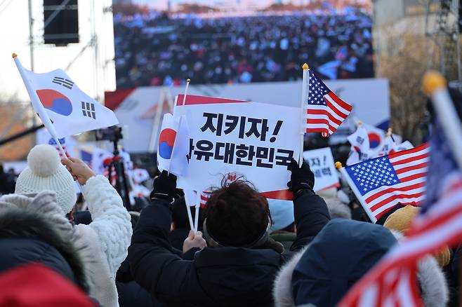 지난 2월 22일 대전 서구 대전시청 앞 보라매공원에서 열린 세이브코리아 국가비상기도회에서 참가자가 손팻말을 흔들고 있다. 연합뉴스