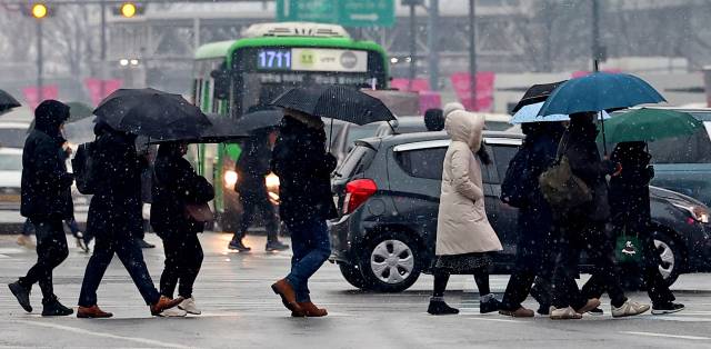 지난달 12일은 눈이 내린 서울 종로구 세종로 사거리 일대에서 시민들이 출근하고 있다. 연합뉴스