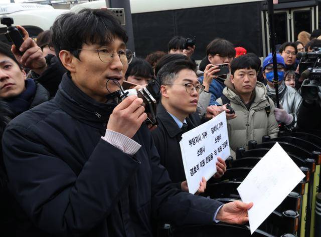 차성안 서울시립대 법학전문대학원 교수가 지난 1월 13일 오후 서울 용산구 한남동 관저 앞에서 경호처 관계자에게 부당지시거부 소명서 전달에 앞서 경호처 직원과 가족용 법률상담 7문7답 질문지를 읽고 있다. 연합뉴스