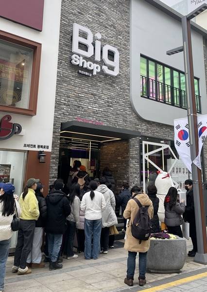 부산 브랜드숍(Big Shop) 앞에 늘어선 방문객들. 매장 입구부터 인도로 이어진 대기 줄이 브랜드숍에 대한 높은 관심을 보여준다.