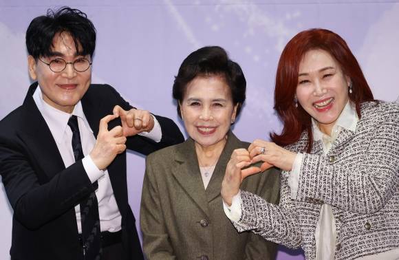 이미자(가운데)가 5일 서울 마포구 한 호텔에서 열린 전통가요 헌정 공연 ‘맥을 이음’ 기자간담회에 참석해 후배 가수 조항조(왼쪽), 주현미와 나란히 서서 활짝 웃고 있다. 이미자는 “전통가요의 맥을 잇는 후배들과 함께 공연해 매우 행복하고 기쁘다”고 말했다. 연합뉴스